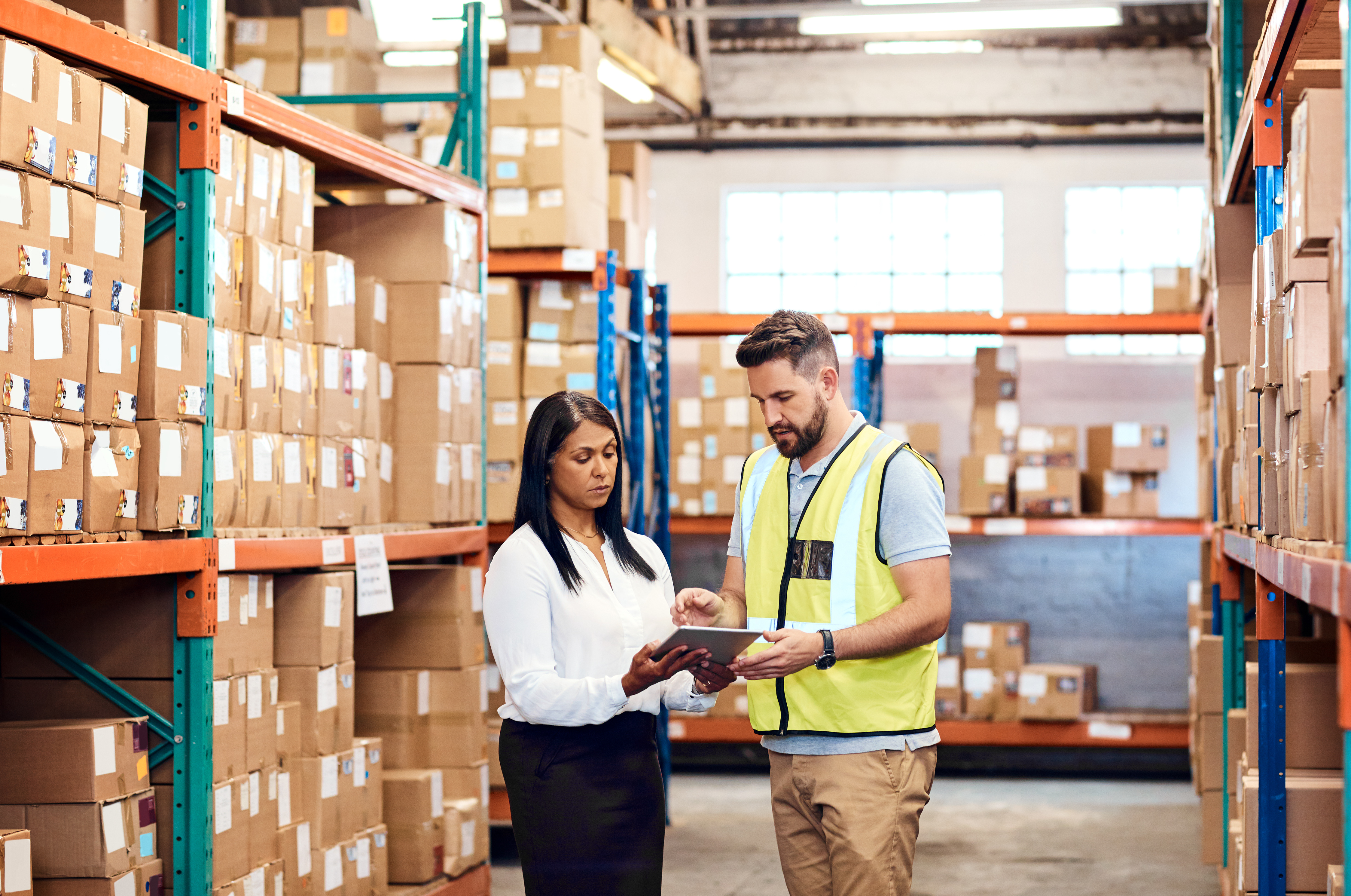 a man and a woman inspecting the warehouse